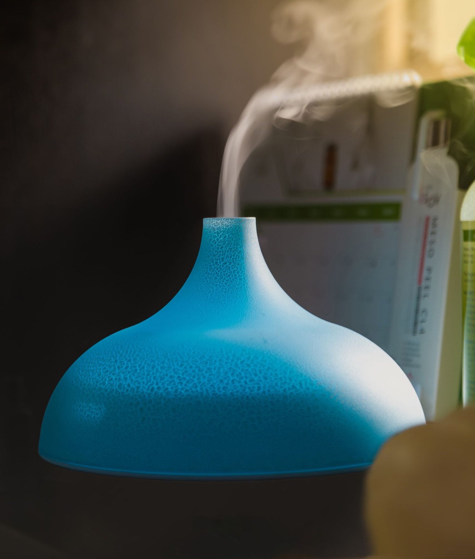 Close-up of a blue humidifier releasing vapor, creating a serene indoor atmosphere.